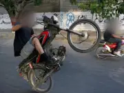 Motorcyclist performs dangerous one-wheeling stunt with girl on front mudguard in Islamabad